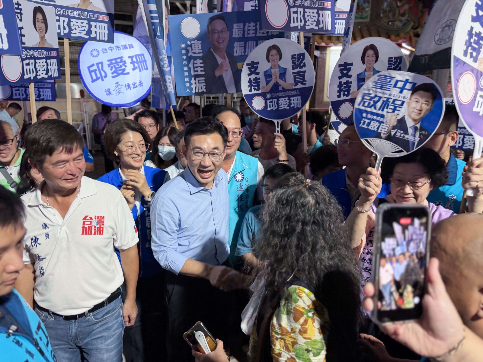 江啟臣走進說明會人群與鄉親握手致意，現場高舉支持議員與參選人的旗幟與扇牌