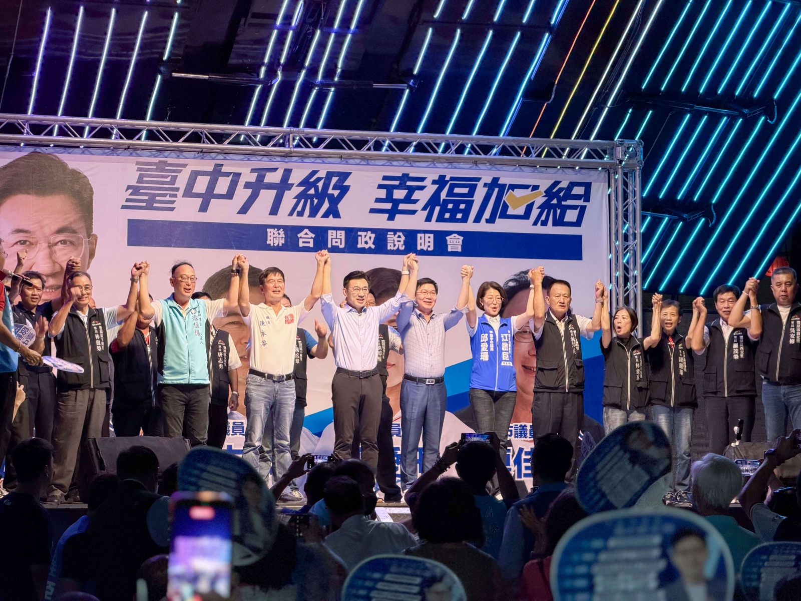 說明會尾聲，江啟臣與地方民代、里長在舞台上高舉雙手，全場高呼「臺中升級、幸福加給」
