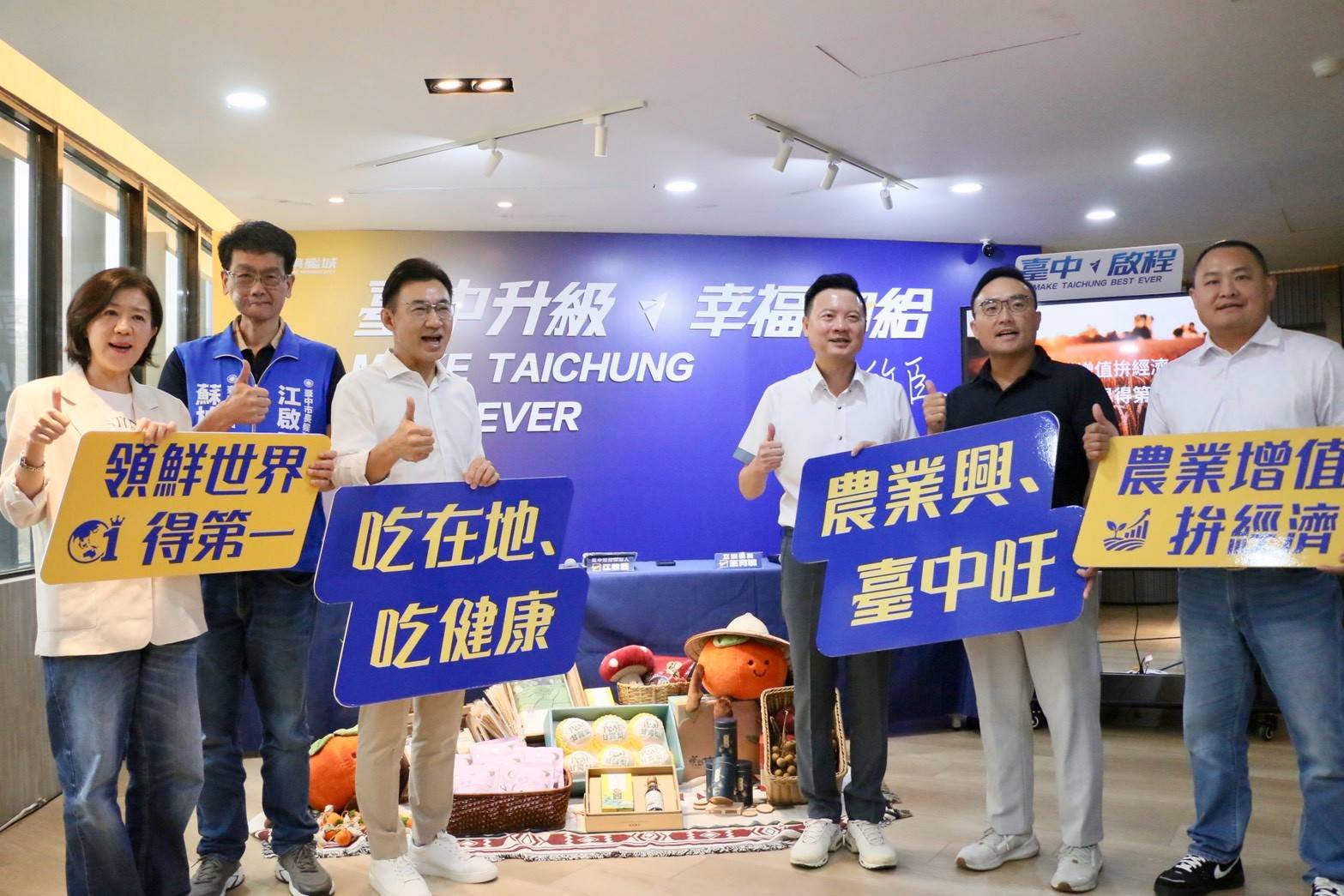 江啟臣與出席來賓手持「領鮮世界得第一」「吃在地、吃健康」「農業興、臺中旺」「農業增值拚經濟」標語牌合影比讚
