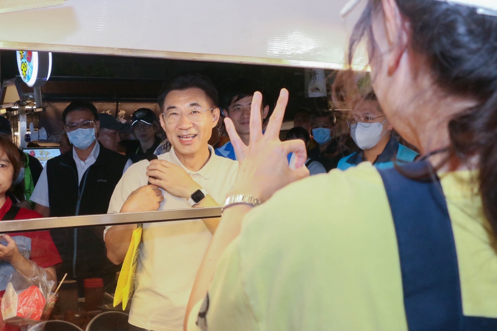 夜市攤商隔著攤台與江啟臣熱情互動，比出手勢為他加油