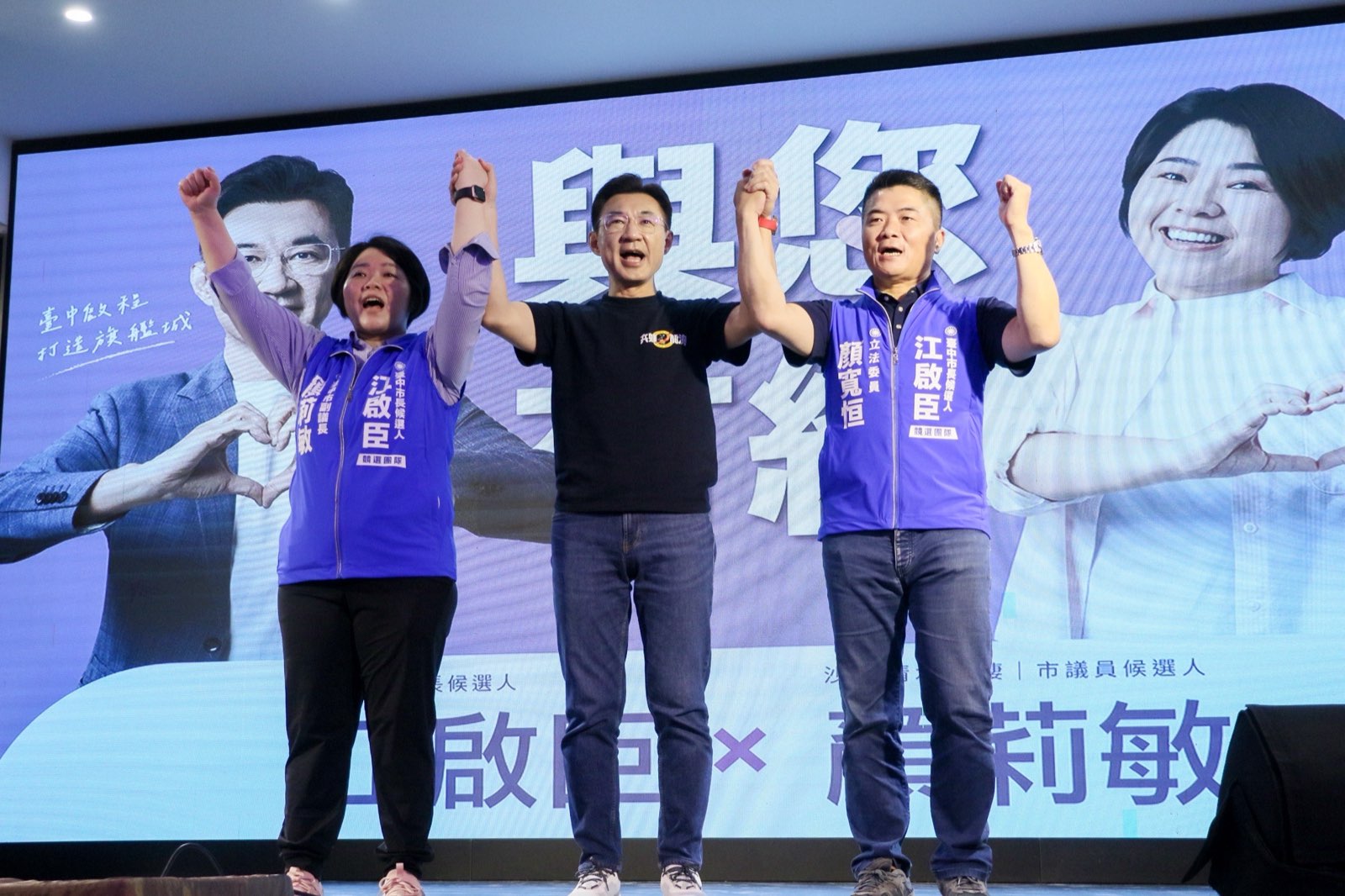 江啟臣與副議長顏莉敏、立委顏寬恒在說明會舞台上牽手高舉，向現場鄉親致意