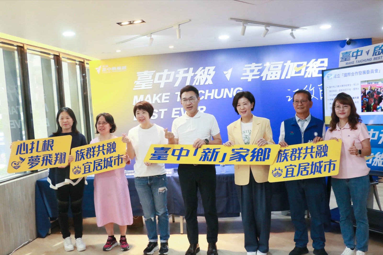 江啟臣與出席來賓手持「臺中『新』家鄉　族群共融　宜居城市」與「心扎根　夢飛翔」看板合影
