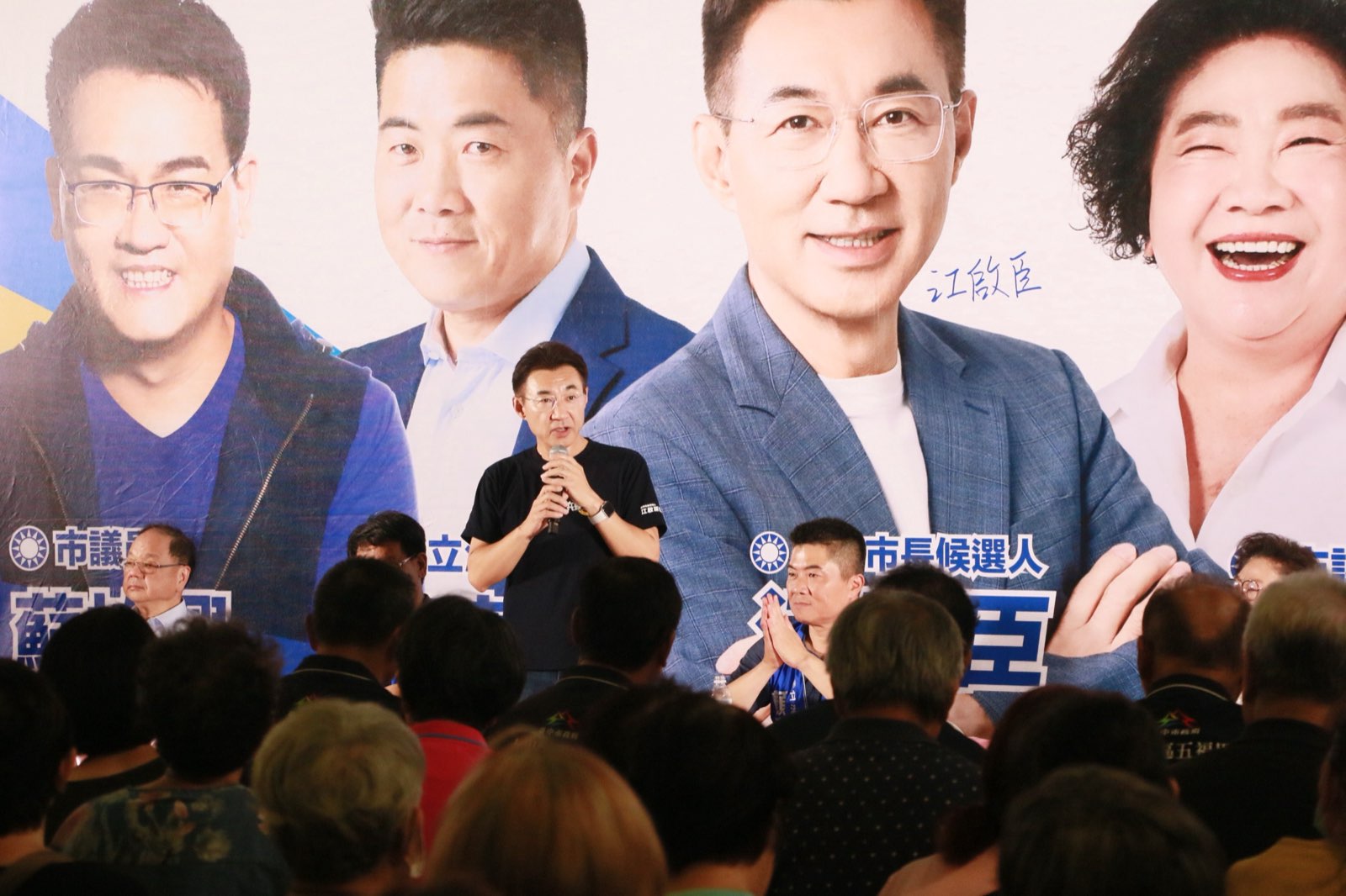 江啟臣站在霧峰說明會台前持麥克風向鄉親說明政見，立委顏寬恒坐在一旁