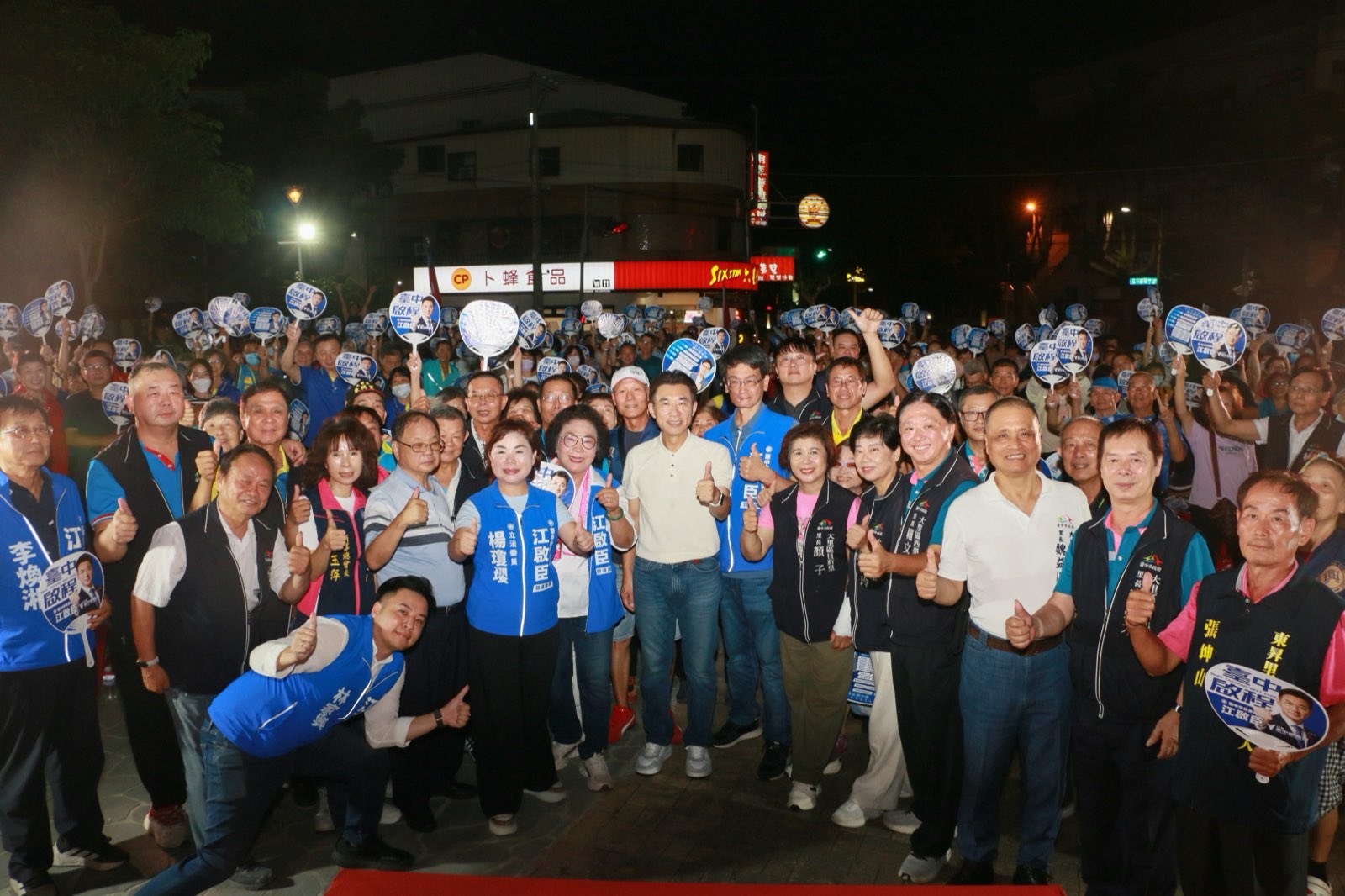 北大里問政說明會夜間大合影，江啟臣與立委楊瓊瓔、市議員及里長比讚，後方鄉親高舉應援扇