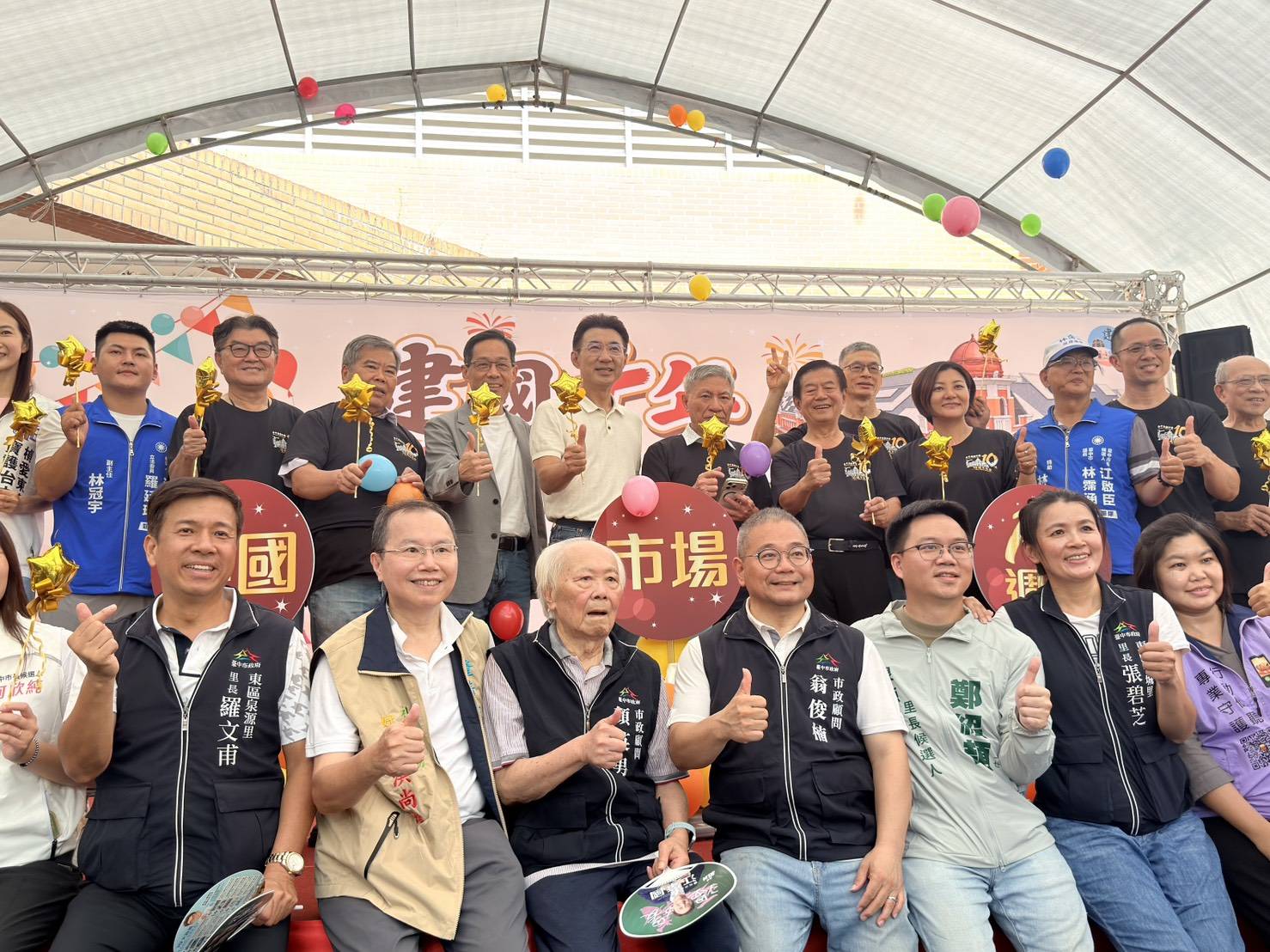 江啟臣與市場自治會幹部、在地民意代表及里長在慶祝活動舞台上比讚合影