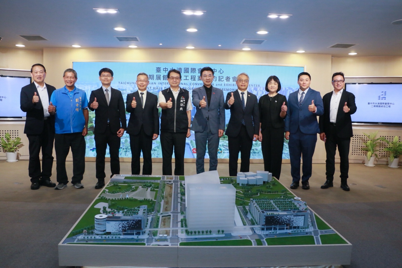 與會貴賓在會展中心二期展館模型前比讚大合照