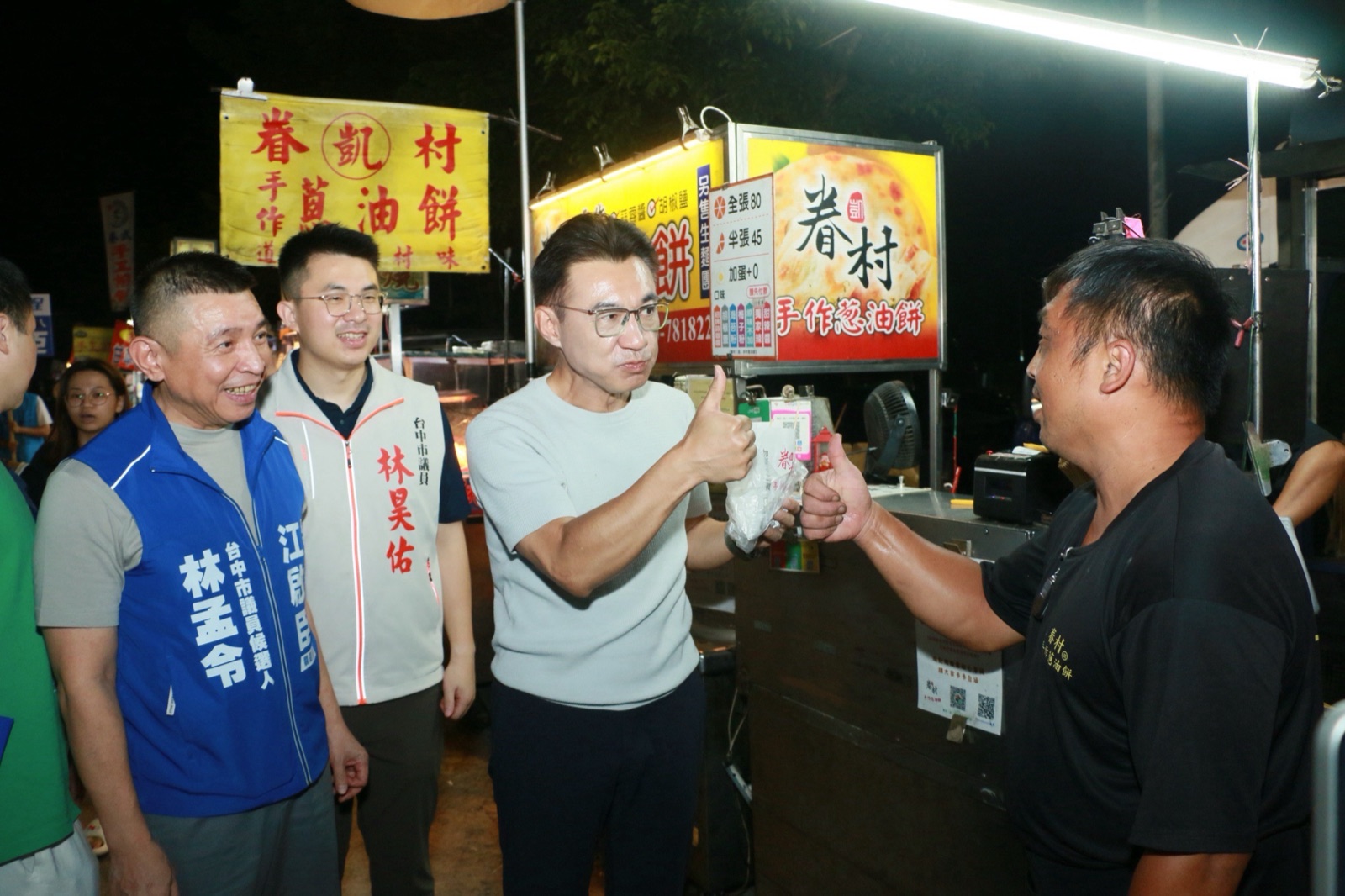 「海龍蛙兵」學弟的攤商送上自家煎製的蔥油餅，江啟臣比讚道謝