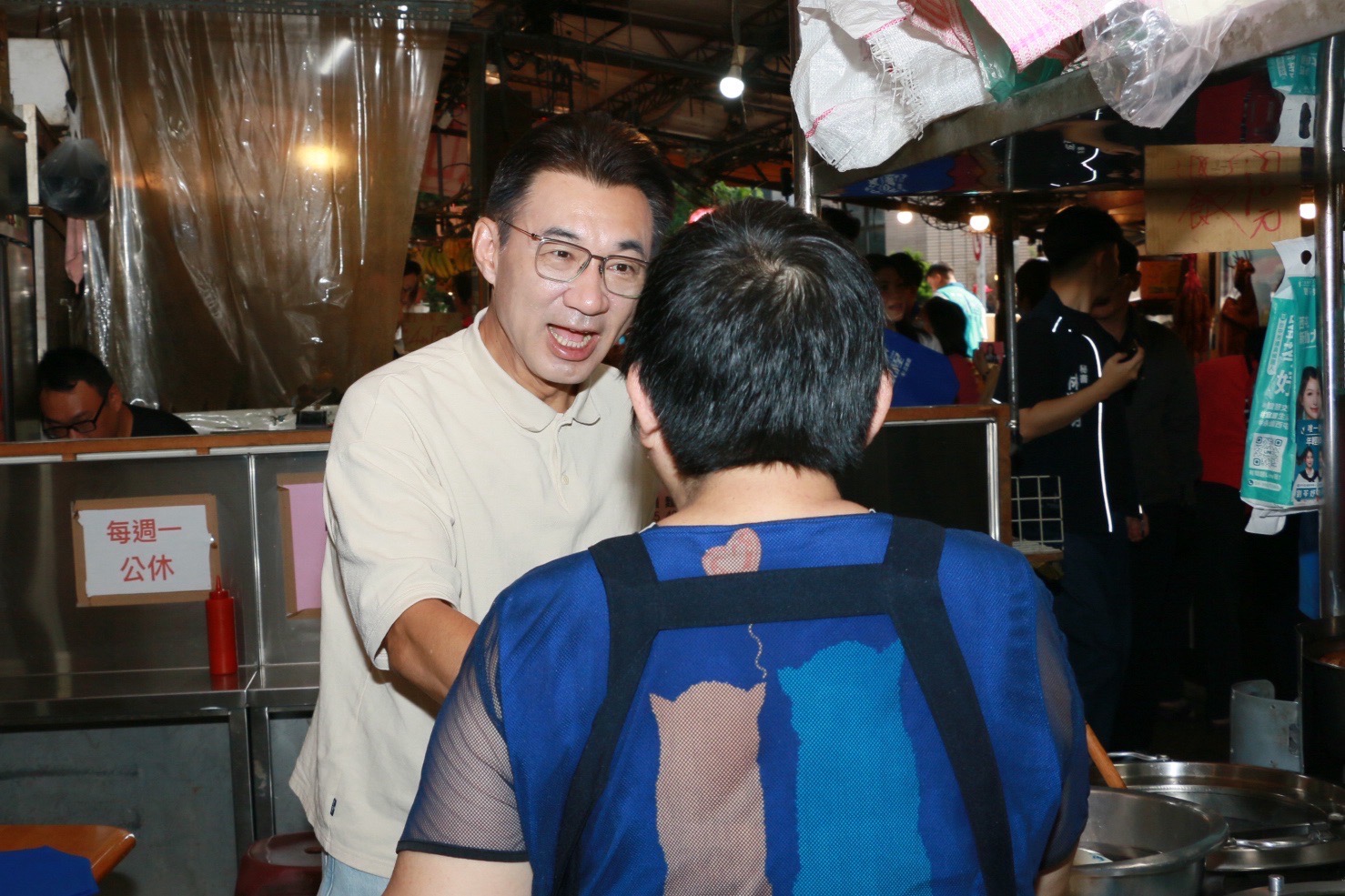 江啟臣彎身與熟食攤攤商握手致意