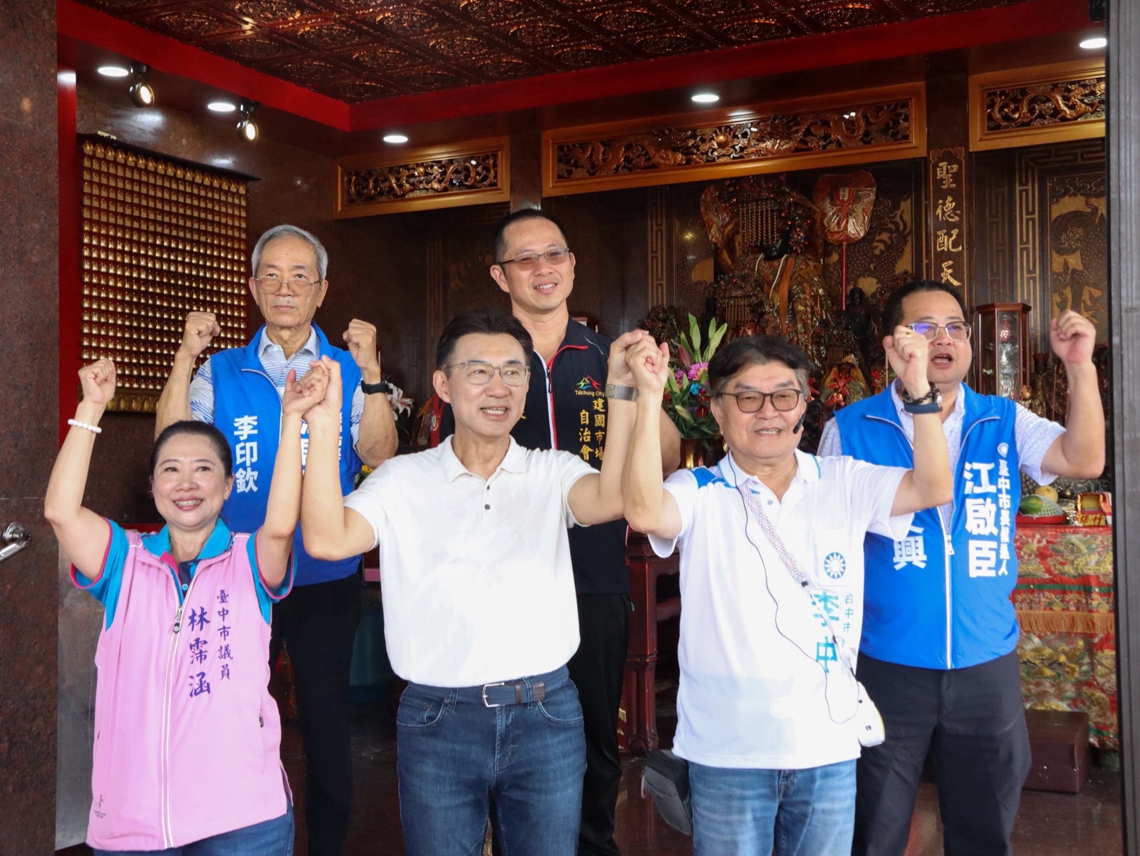 江啟臣與市議員林霈涵、李中及建國市場自治會人員、地方人士在市場內牽手高舉，為選戰加油