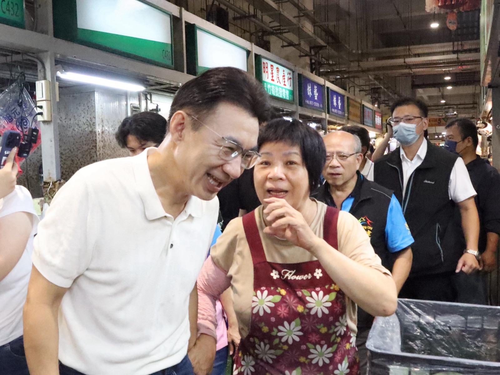 江啟臣彎身與建國市場攤商交談，聆聽攤商心聲