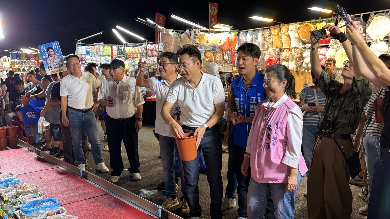 江啟臣與市議員林霈涵、李中、立委羅廷瑋在套圈圈攤位前互動