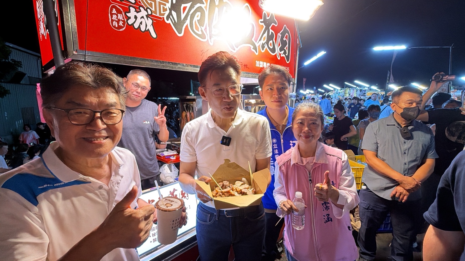 江啟臣手拿現炸小吃與飲料，與立委羅廷瑋、市議員林霈涵在夜市攤位前合影