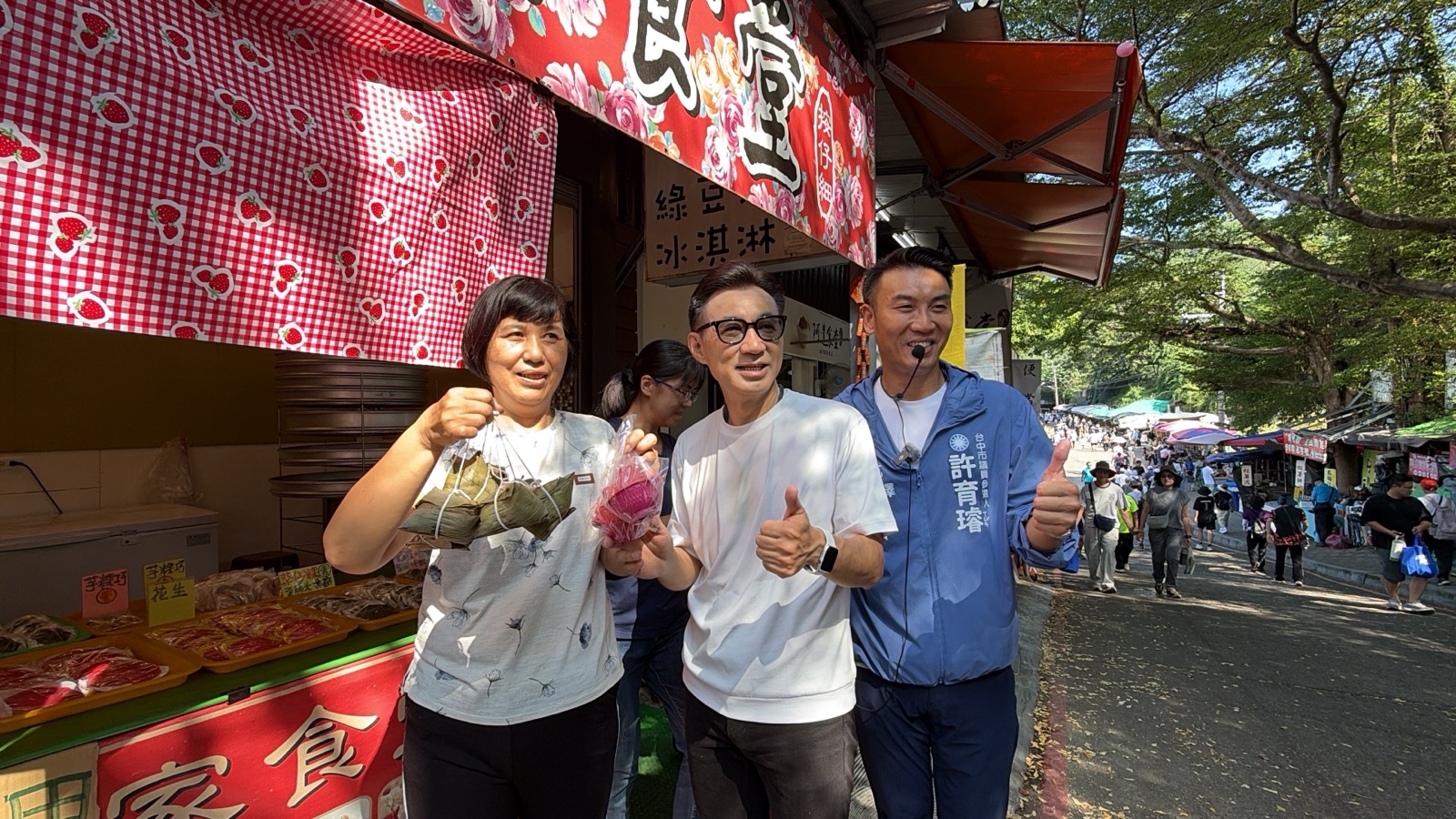 大坑美食「魚丸伯」攤商送上整包魚丸，江啟臣與市議員候選人許育璿收下老闆的心意