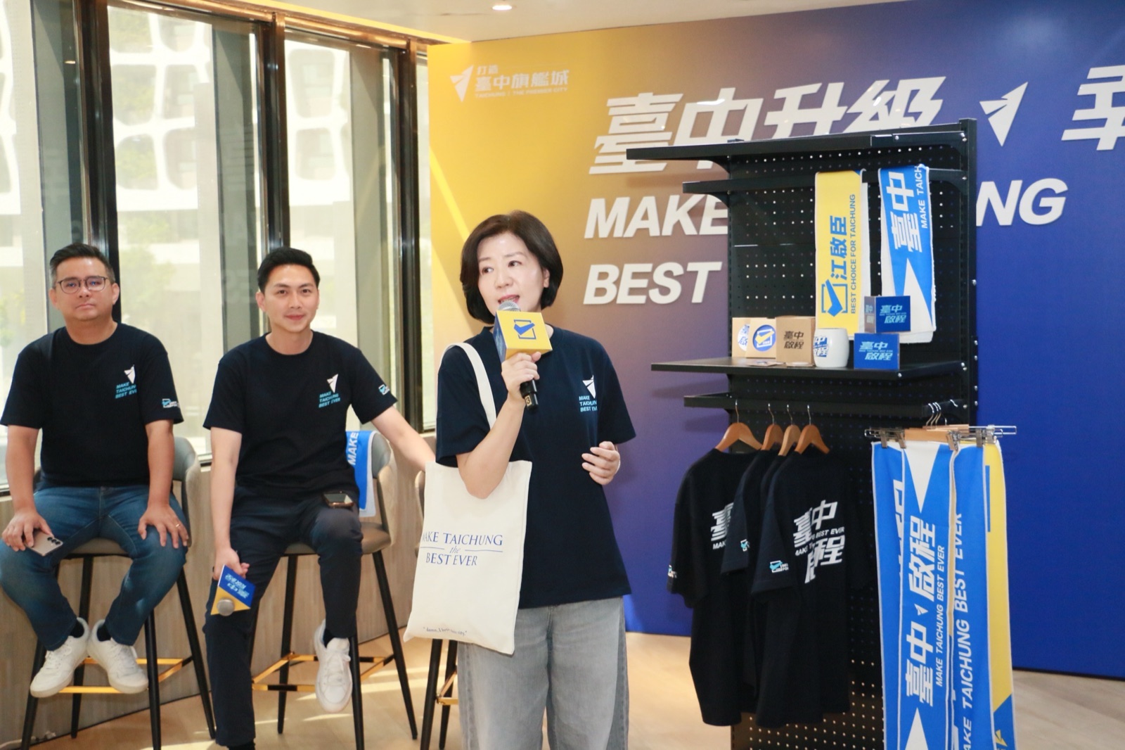 王育敏手持環保帆布袋，介紹本次募款小物