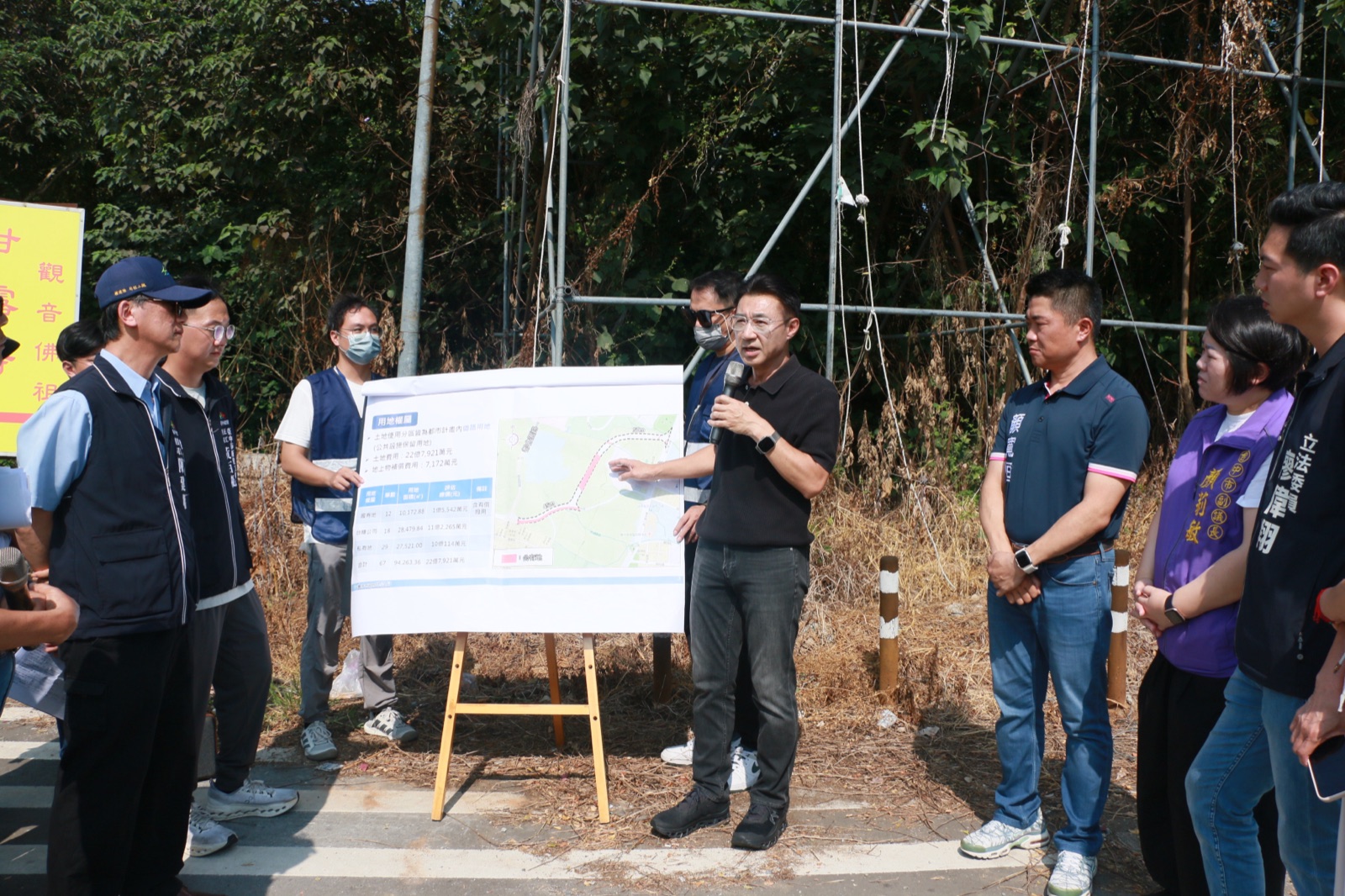 江啟臣在西屯區特五號道路延伸工程預定地，面對用地權屬圖板發言；立委顏寬恒、副議長顏莉敏、立委廖偉翔與市府人員在旁聆聽