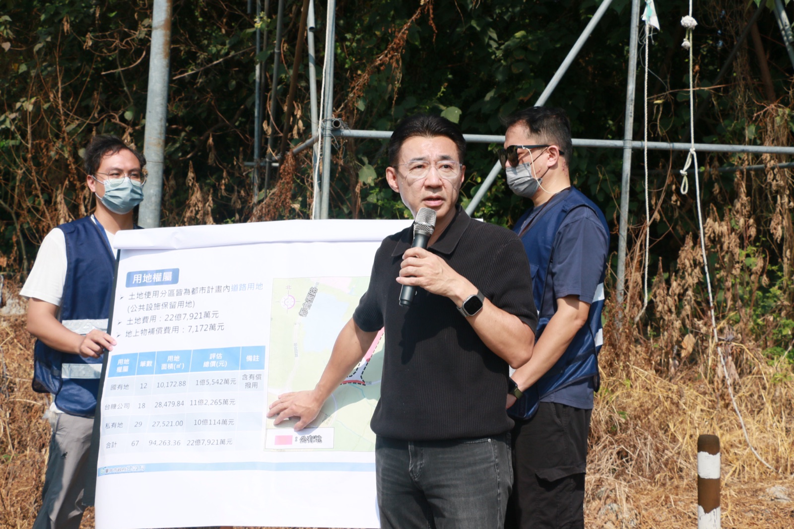 江啟臣手持麥克風，說明特五號道路延伸工程的用地權屬與經費