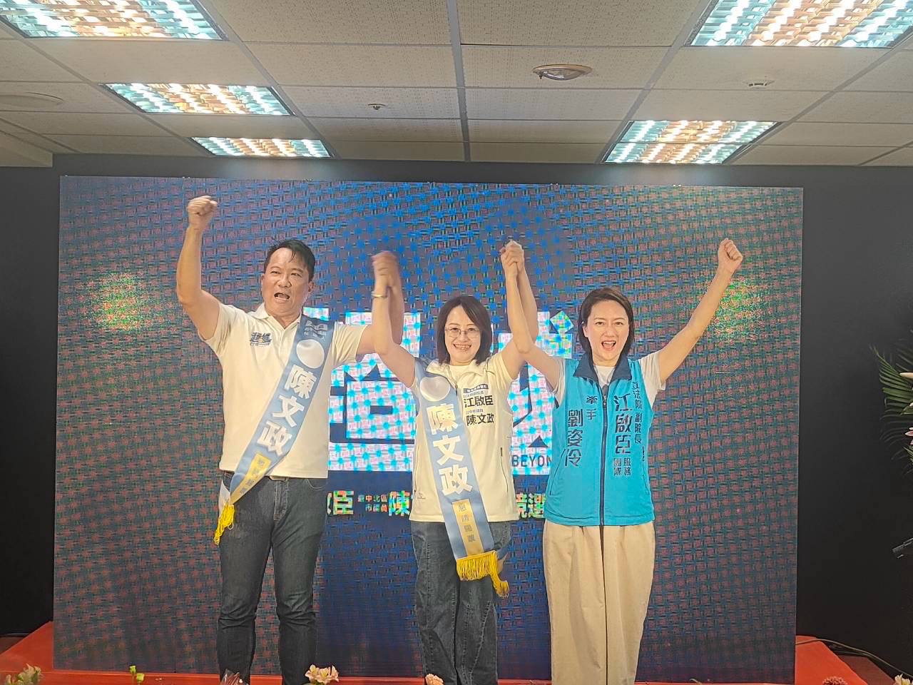 陳文政競選總部成立大會，陳文政、一位女士與身穿「江啟臣服務團隊」背心的劉姿伶牽手高舉