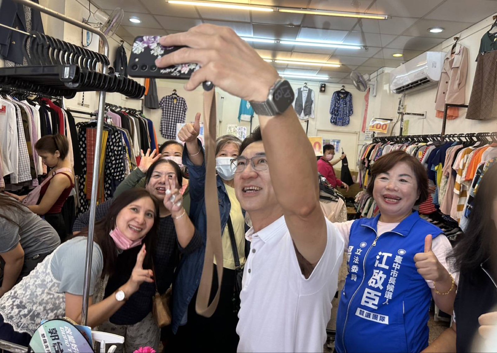 江啟臣在大雅市場服飾店舉高手機，與楊瓊瓔及店內民眾一起自拍