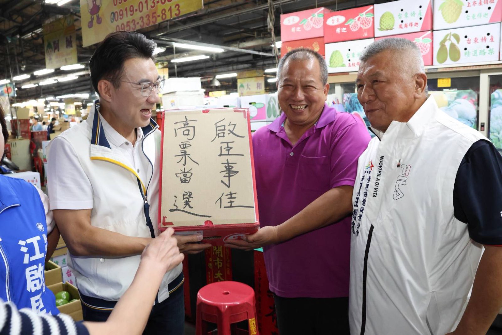 攤商手持寫著「啟臣事佳、高票當選」的紙箱，與江啟臣合影