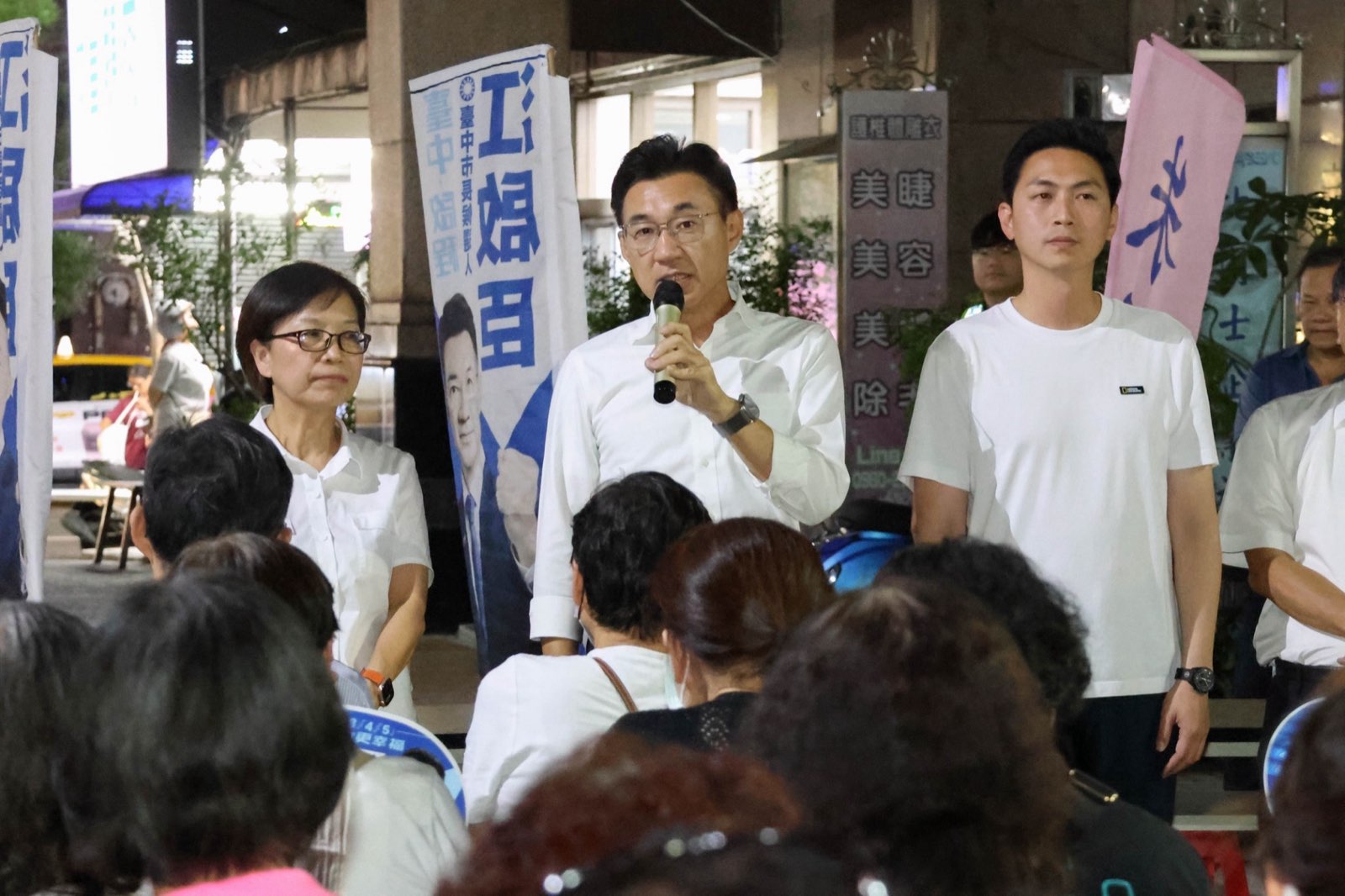 江啟臣持麥克風向南屯鄉親說明育兒與敬老政策，朱暖英、廖偉翔在旁