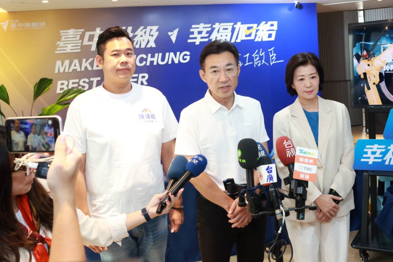 記者會後多家媒體的麥克風湊近收音，穿白色Polo衫的男子與穿「陳清崧」白T的男子、穿米白西裝的女士並排站在「臺中升級 幸福加給」背板前接受採訪