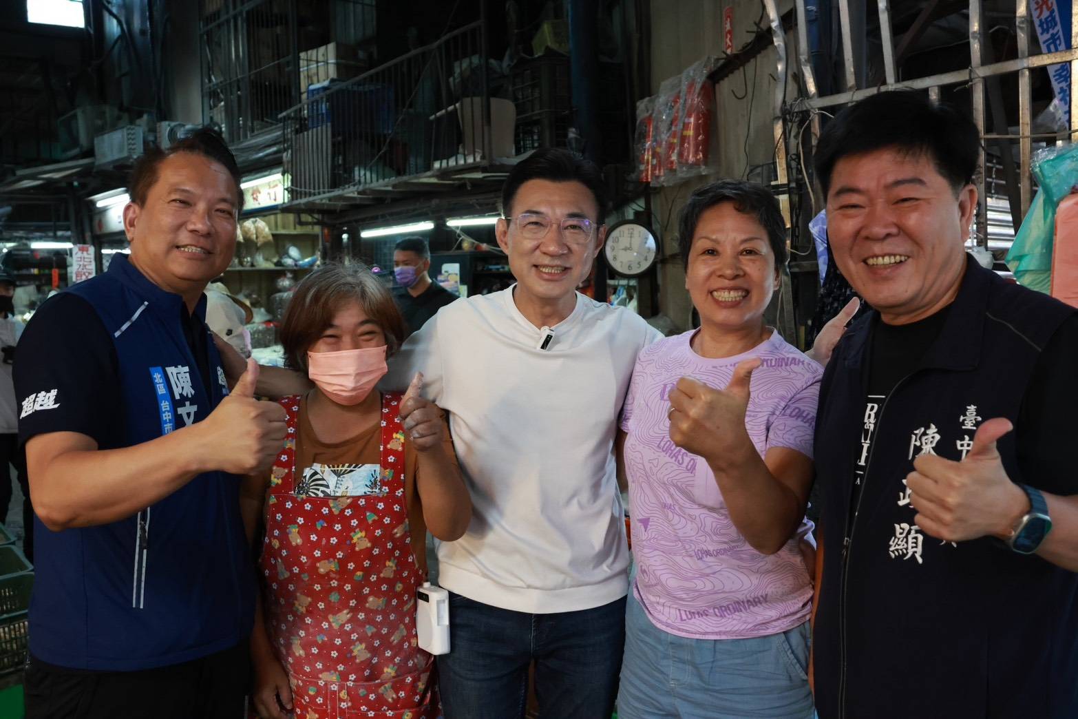 東興市場內，穿白色上衣的男子與穿藍色「陳文政」背心、穿深色「臺中市議員 陳政顯」背心的兩位男子，以及兩位攤商女士並肩合影，眾人比讚