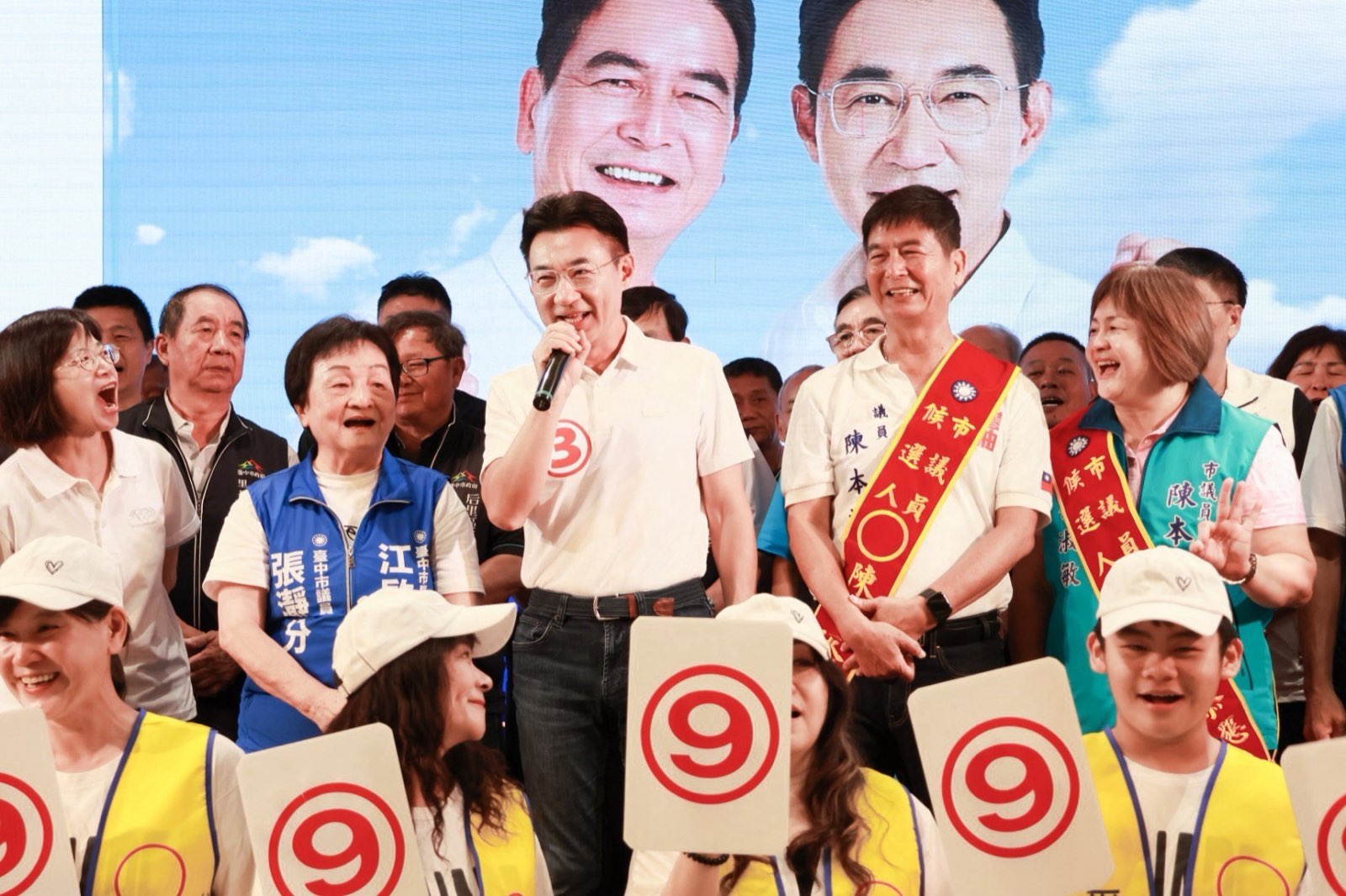 江啟臣持麥克風向鄉親說明市政願景，市議員張瀞分與陳本添在旁