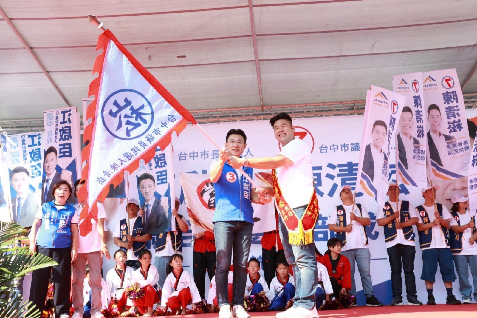 江啟臣為市議員候選人陳清崧授旗，台上小朋友與支持者揮舞旗幟