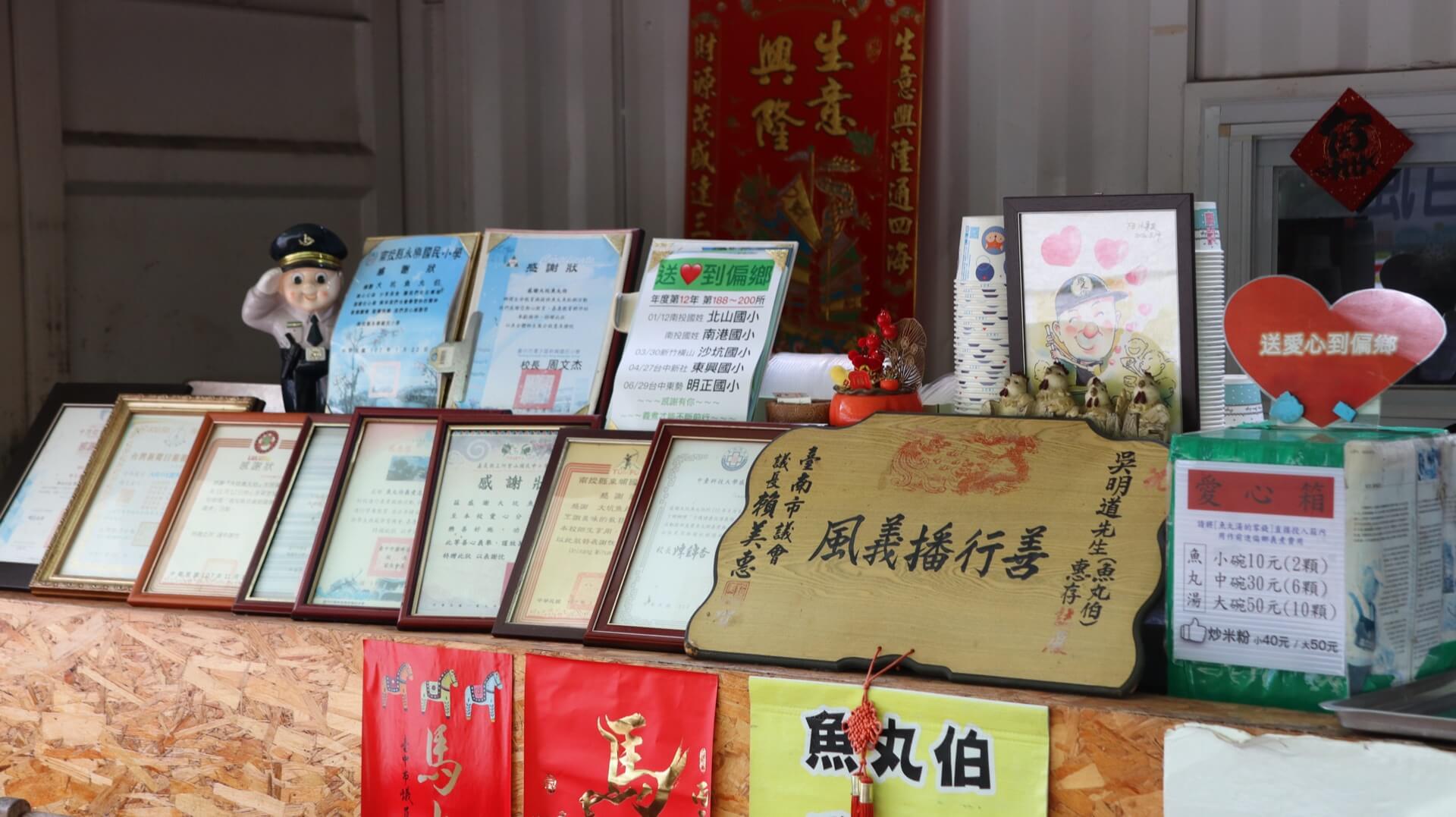 魚丸伯獲頒的感謝匾額與獎狀