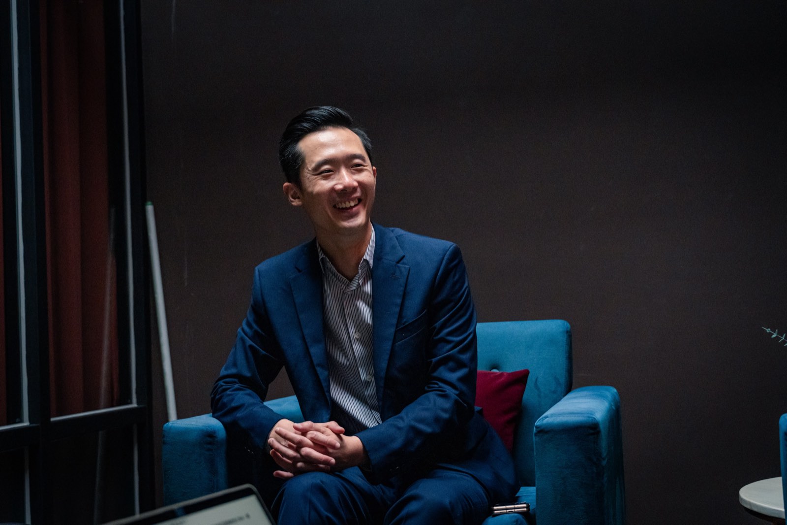 Vender 主理人 Darren 坐在店內的藍色扶手椅上受訪，開懷大笑