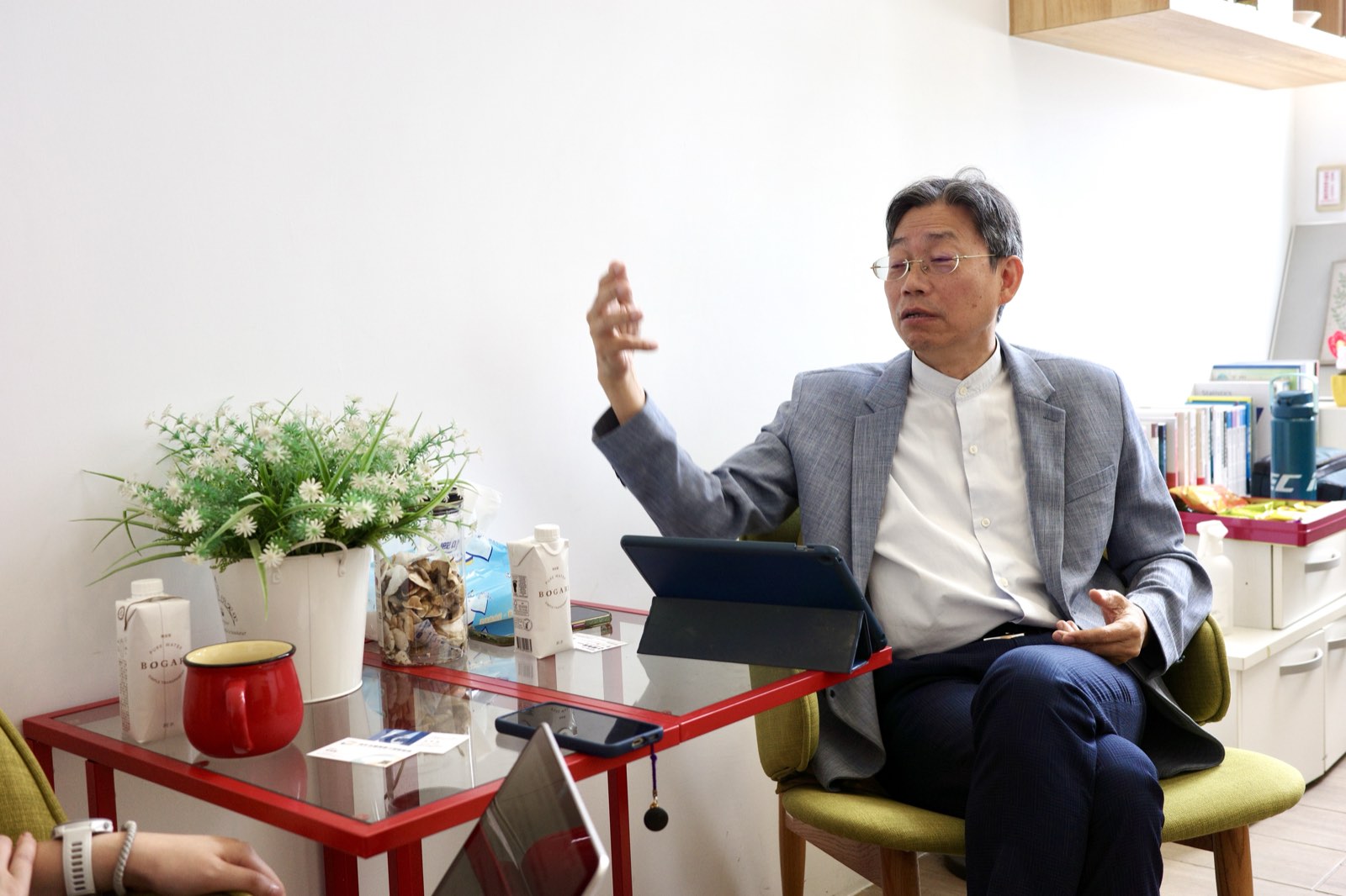 青年永續領導力發展協會理事長周學鏵坐著受訪，一邊說話一邊比著手勢