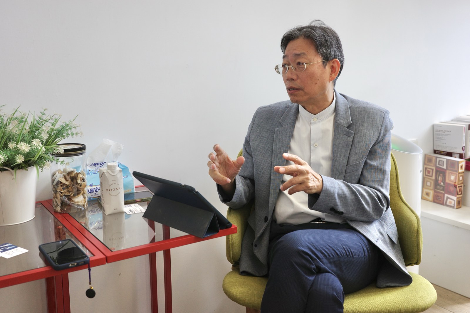 周學鏵坐在椅子上，邊說邊用手勢比劃